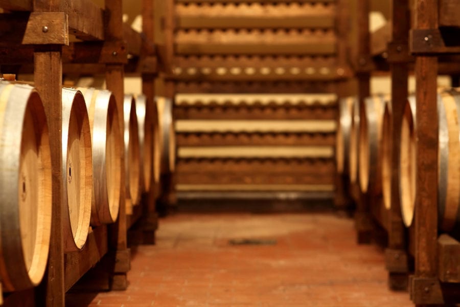 corridor with wine barrels on the wood panels on the both sides at Orealios Gaea cellar